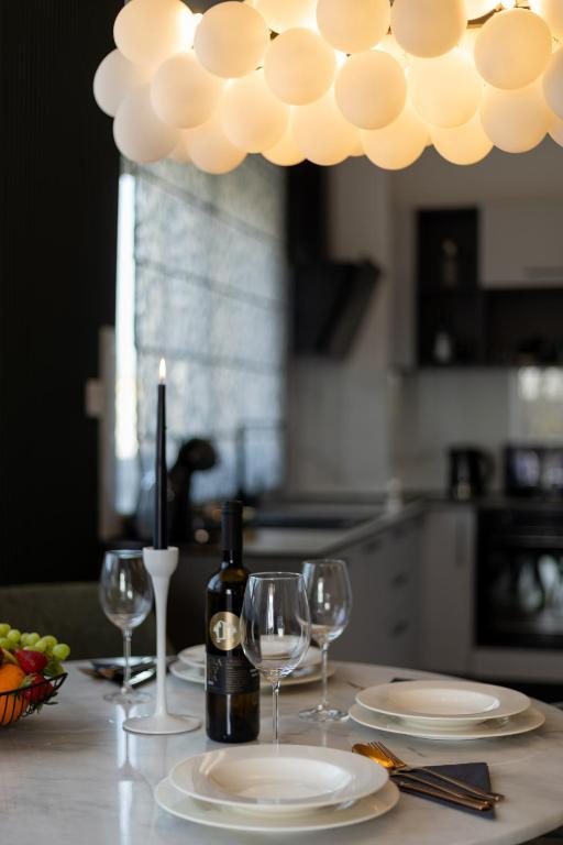 a table with plates and wine glasses and a chandelier at Luxury Opus Osijek - Self Check in, Free Private Parking in Osijek