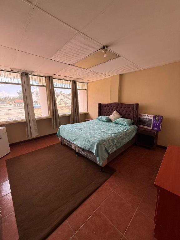 a bedroom with a bed in a room with windows at casa zona 10 in Lo de Contreras