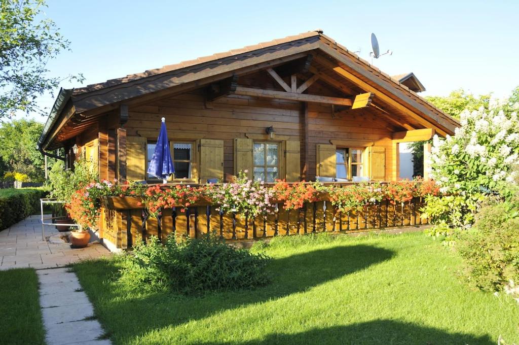 a log cabin with a fence in the yard at Blockhaus Rosa Reischl in Neubeuern
