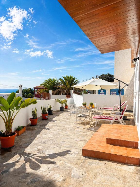 a patio with a table and chairs and the ocean at Casa Rural Encantadora Con Terraza Privada in Arona