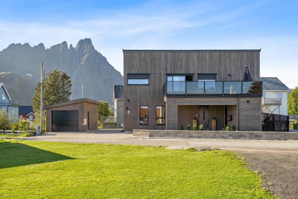 a house with a mountain in the background at Moderne hus midt i Lofoten in Ballstad