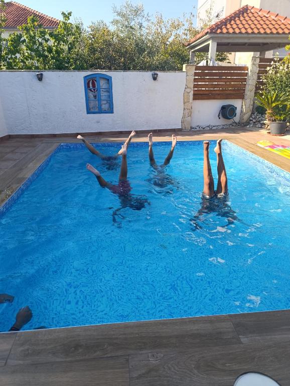 a group of people in a swimming pool at Villa Olma in Okrug Gornji