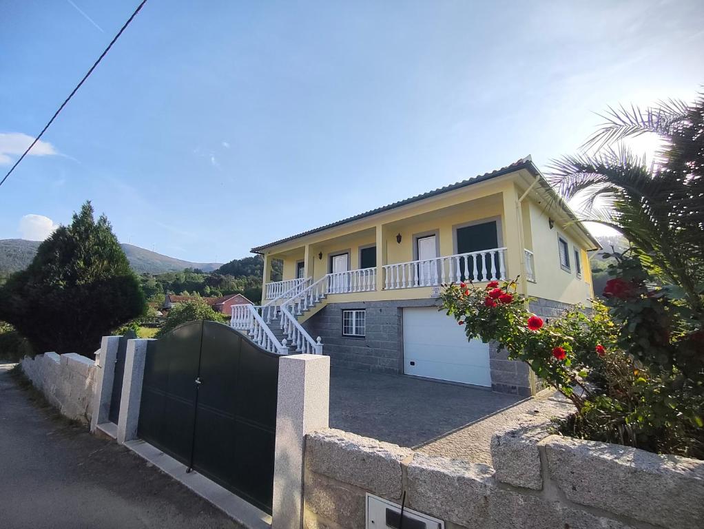 a yellow house with a gate and a fence at Casa do Reguengo in Arouca