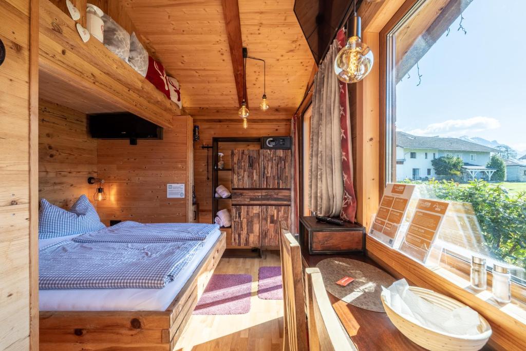 a bedroom with a bed and a large window at Tiny House Singer - contactless check-in - Sauna in Ehenbichl