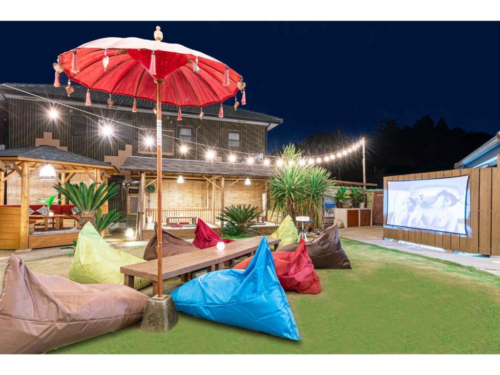 a picnic table with a red umbrella in a yard at THINK - Vacation STAY 30630v in Ichigaya