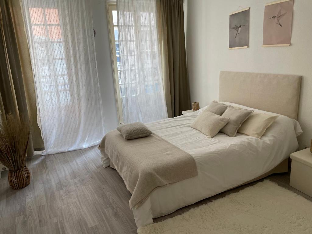 a white bedroom with a large white bed with pillows at Sand Home in Le Puy-en-Velay