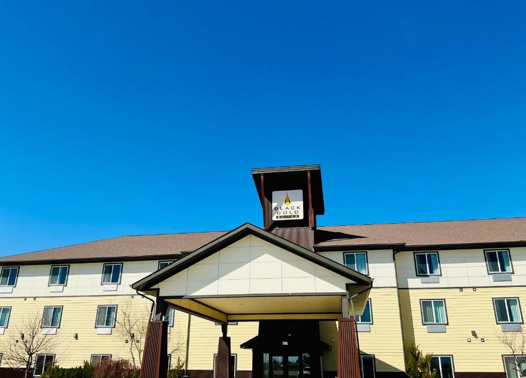 a building with a clock tower on top of it at Black Gold Suites Tioga in Tioga