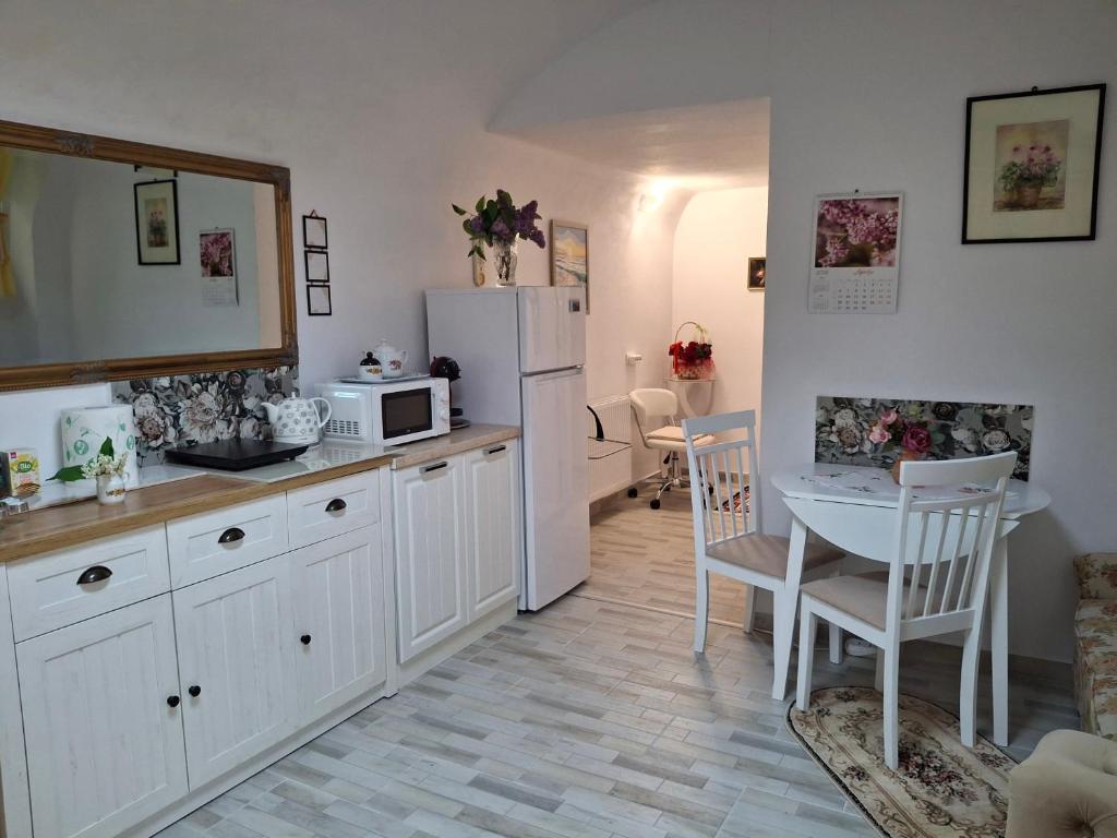 a kitchen with a table and a white refrigerator at Ultracentral STUDIO Koket in Arad