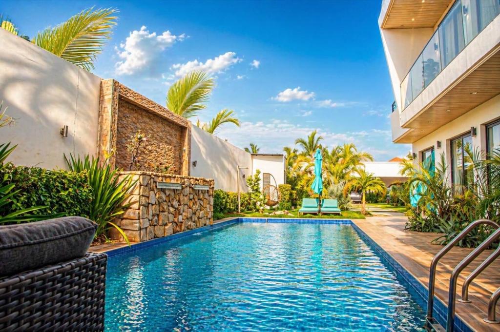 a swimming pool in front of a house at Chambres Complexe luxueux Saly-MaliKounda in Malikounda