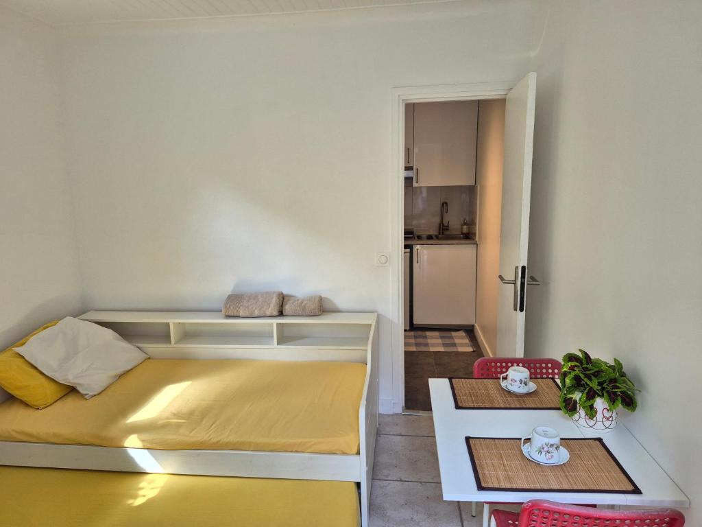 a small bedroom with a bed and a table at Studio Neuf et indépendant in LʼÉtang-la-Ville
