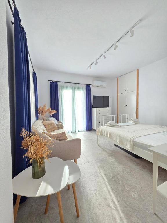 a bedroom with a bed and a couch and a table at Sun & Moon Studio Afitos in Afitos