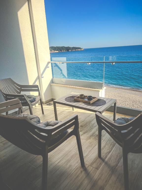 a balcony with two chairs and a table and the ocean at Amare&Mare Apartment in Sutomore