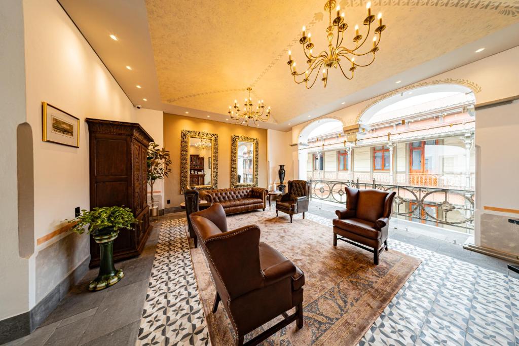 a living room with chairs and a chandelier at Hotel Emperador Orizaba in Orizaba