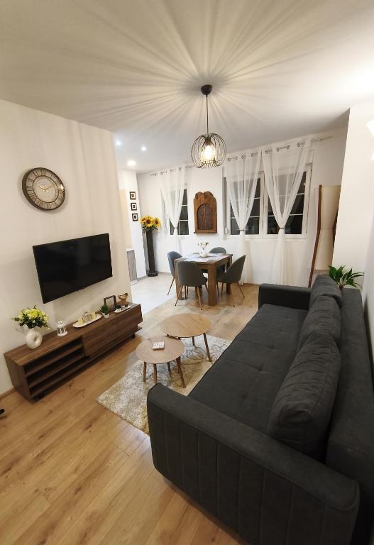 a living room with a black couch and a table at Little Vine House in Mostar
