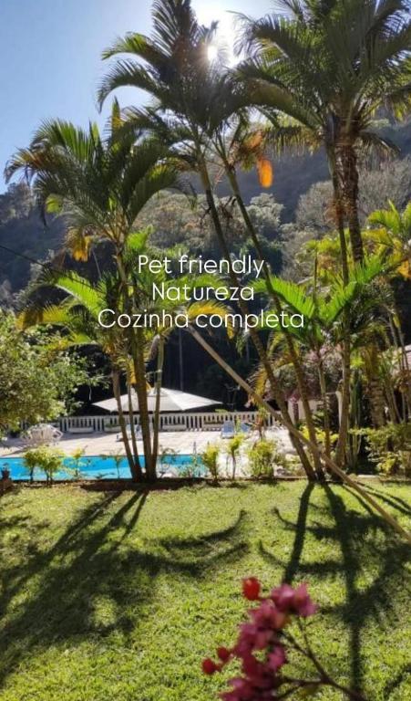 a resort with palm trees and a swimming pool at Vila da Sol Itaipava casas e estúdios in Itaipava