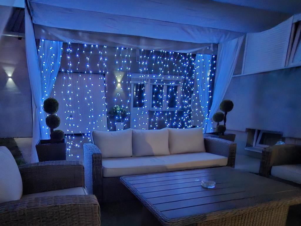 a living room with a couch and a window with lights at Studio apartman Aria in Đakovo
