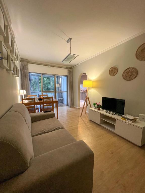 a living room with a couch and a television at 2BR Estoril Apartment - Near Estoril Beach & Cascais - Sleeps 4 in Estoril