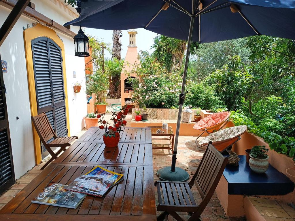 a wooden table with an umbrella on a patio at Casa Algiana - Private Pool in Loulé