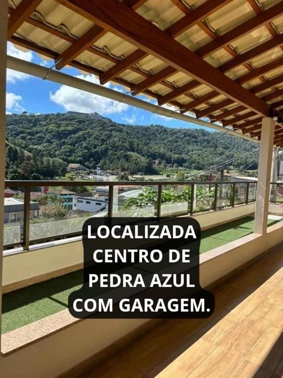 a sign on a balcony with a view of a mountain at Casa Schmidt Centro Pedra Azul in Pedra Azul