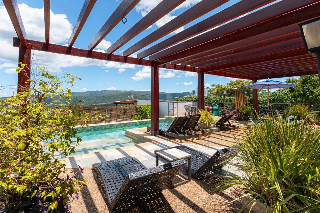 a patio with chairs and a swimming pool at Serra do Juá Pousada de Campo in Pirenópolis