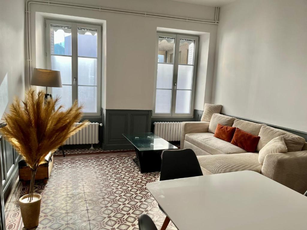a living room with a couch and a table at Maison de ville in Évron