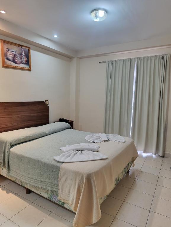 a bedroom with a bed with towels on it at Hotel Ke Kuul in Salta