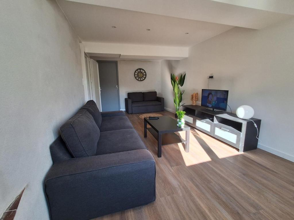 a living room with a couch and a tv at The Cévennes break in Anduze