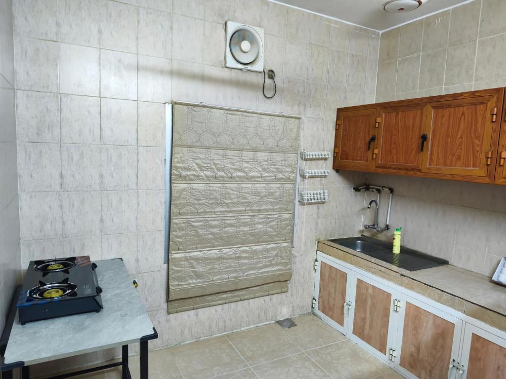 a kitchen with a sink and a stove in it at شقة مفروشة بمدينة نزوى in Fulūj Sayghah