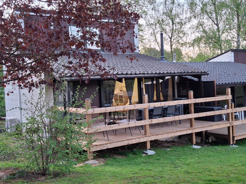 eine große Holzterrasse vor einem Haus in der Unterkunft Chalet douceur in Virton