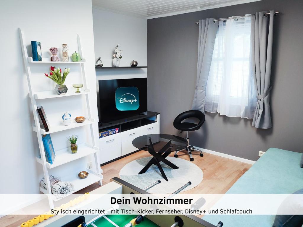 a living room with a television and a chair at GlanzExperts Auszeit bei Berlin Balkon Kicker & DisneyPlus in Zossen