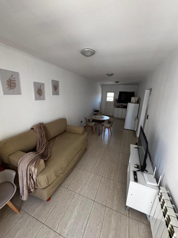 a living room with a couch and a television at La Pampa Apartment in General Roca
