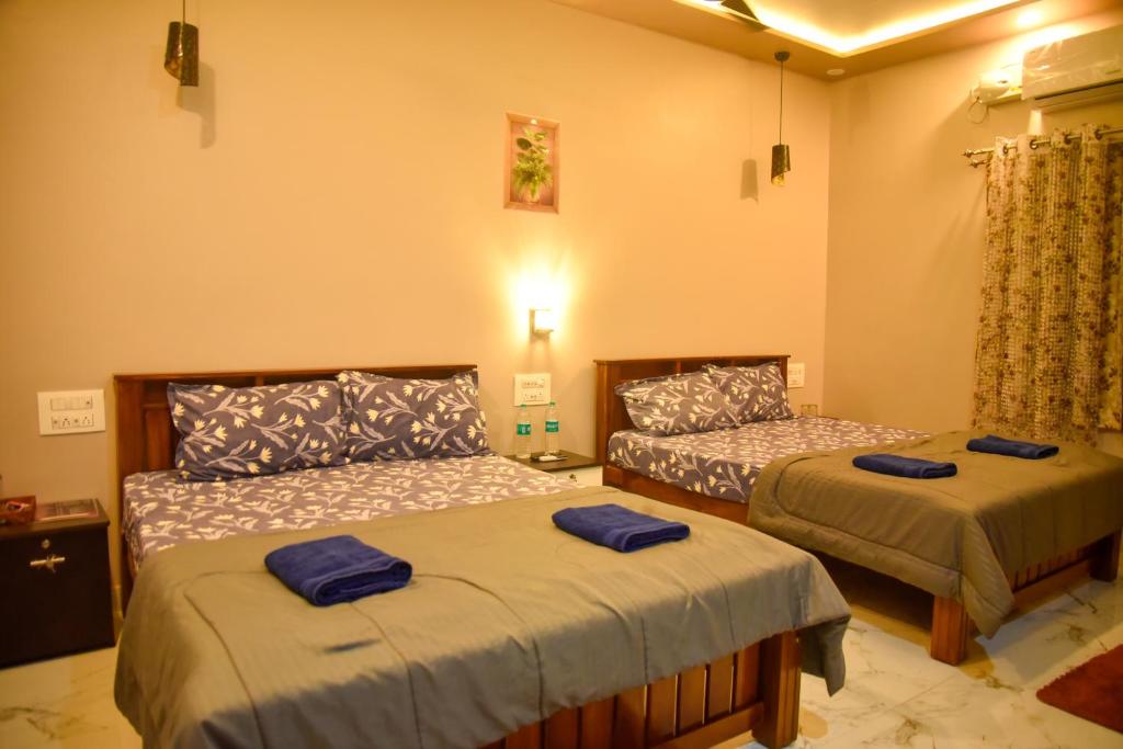 a bedroom with two beds with blue towels on them at JFZ Homestay in Kāsarkod