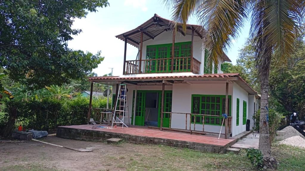 a house being constructed with a green and white facade at Apartaestudio la Ísla in Estación El Salto