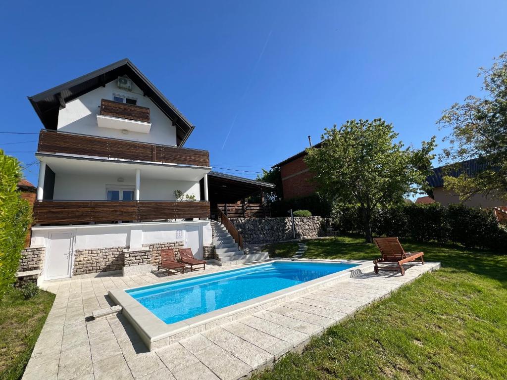 a villa with a swimming pool in front of a house at Villa Otto - Private Pool & Garden in Zagreb