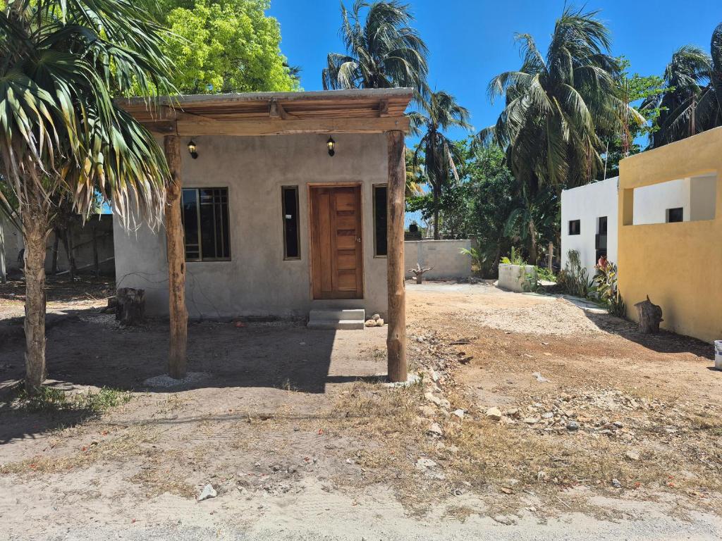 ein kleines Haus mit einer Holztür in einem Hof in der Unterkunft Casa Haema in El Cuyo