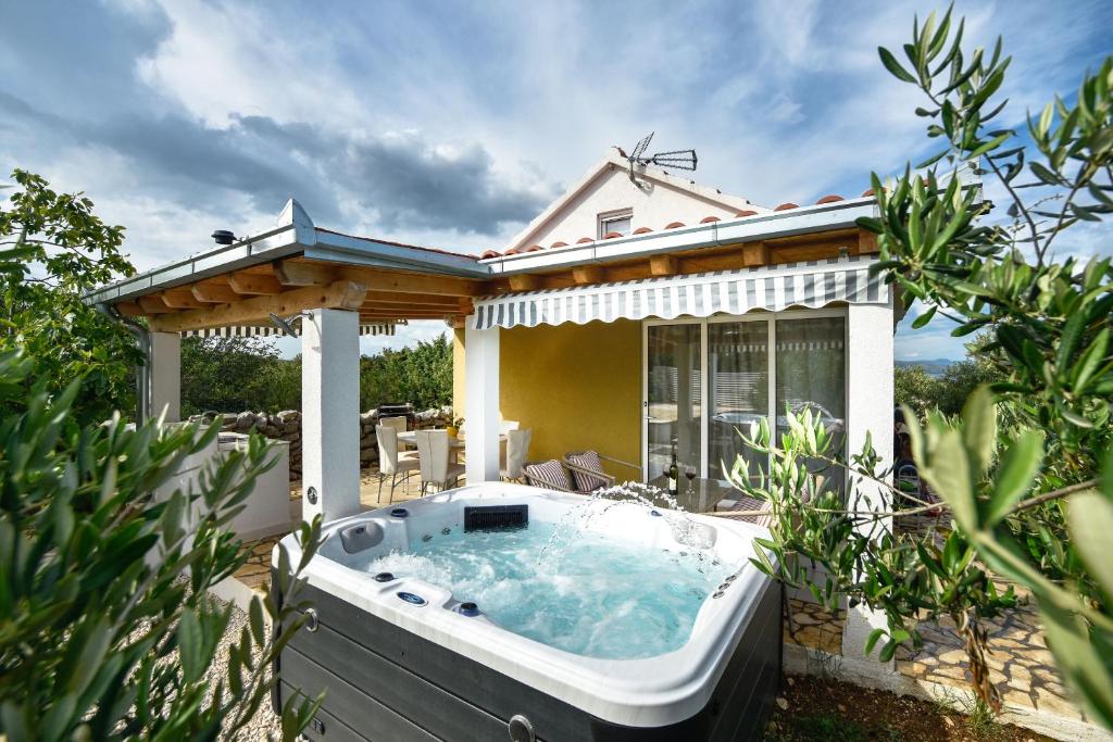 a hot tub in the backyard of a house at House Lila Jacuzzy in Drvenik Mali