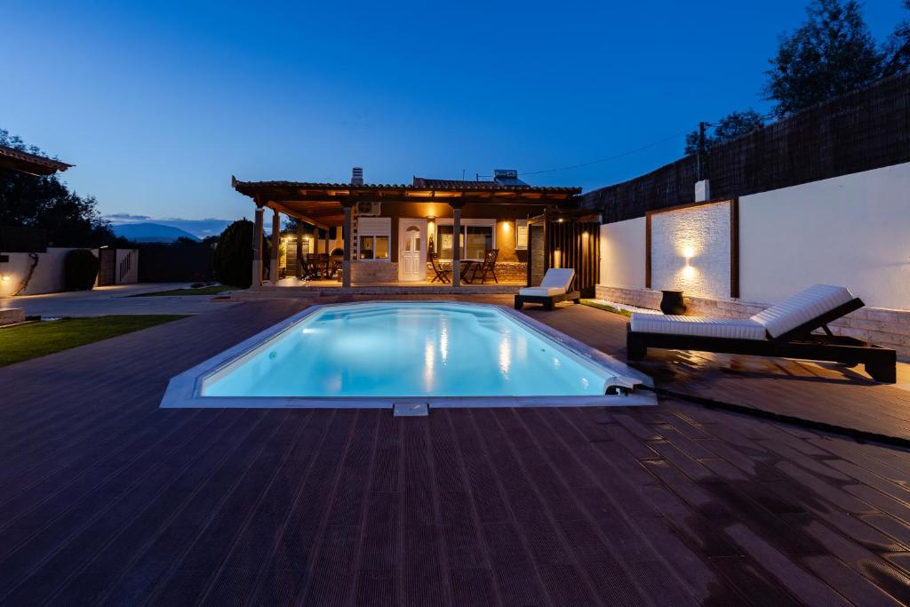 a swimming pool on a deck with a house at SENSEs VILLA SPA in Aghia Marina