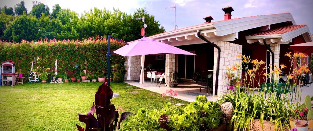 a house with a pink umbrella in a yard at Vita sul Garda in Bardolino