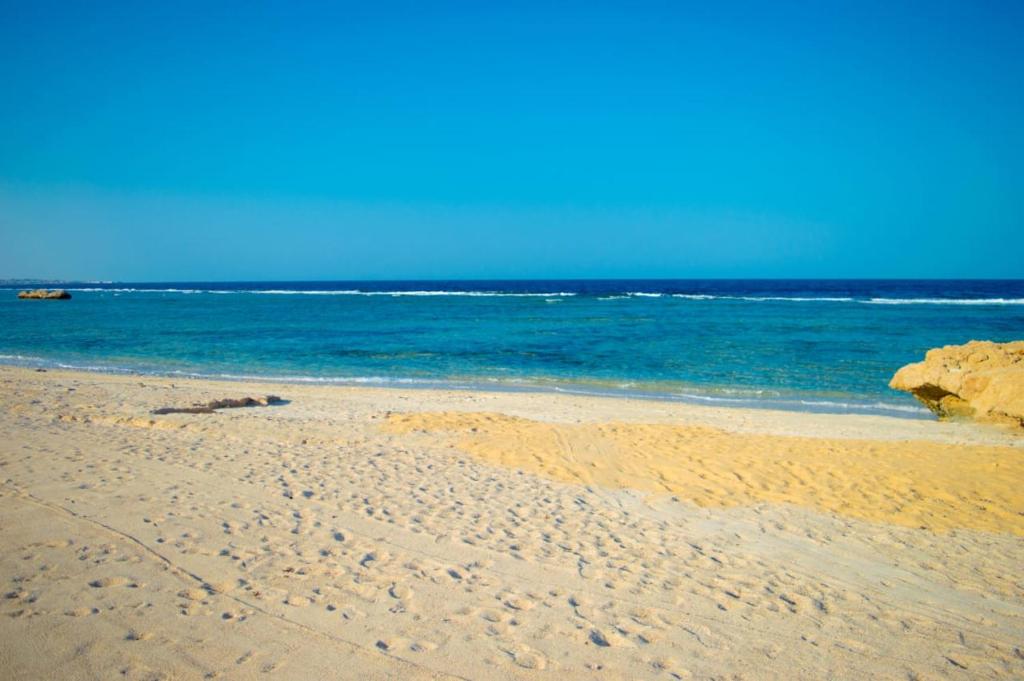 a sandy beach with the ocean in the background at شاليه in Marsa Alam