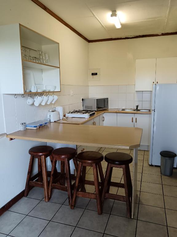 a kitchen with a table and stools in it at Pecan Cottage 2 in Machadodorp
