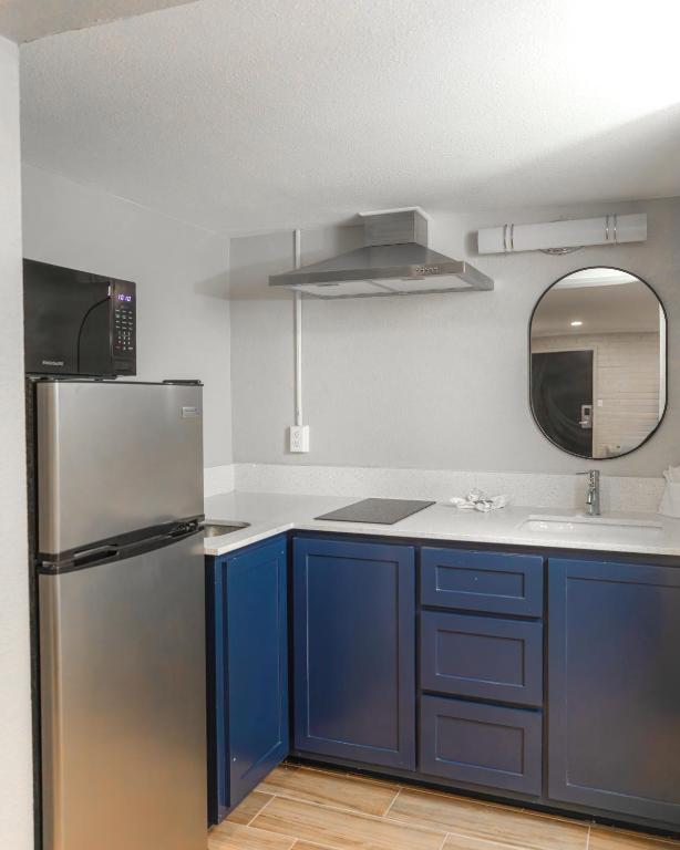 a kitchen with blue cabinets and a stainless steel refrigerator at Gateway Inn in Graham