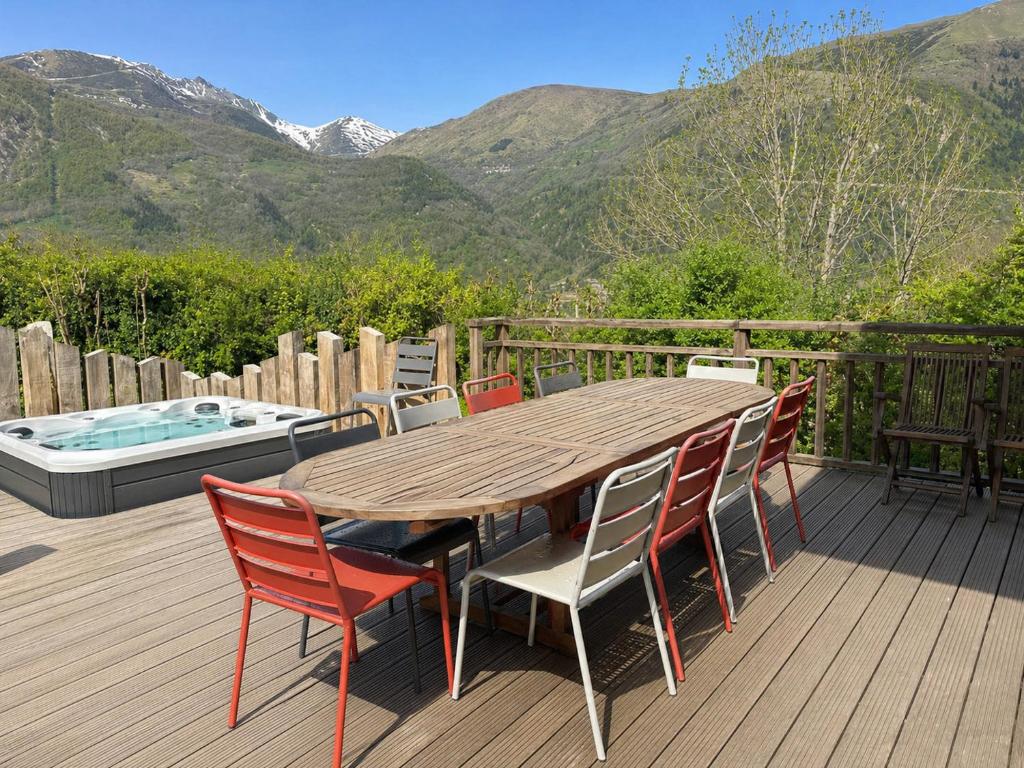 a wooden deck with a table and chairs and a hot tub at Maison Style Chalet 4 étoiles avec Jacuzzi- La Sérénité de Sailhan in Camparan