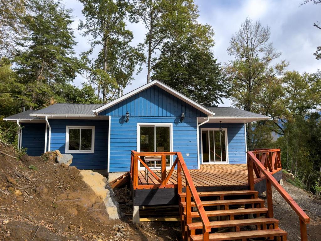 a blue tiny house with a wooden deck at Arriendo casa Caburgua Pucón in Caburgua