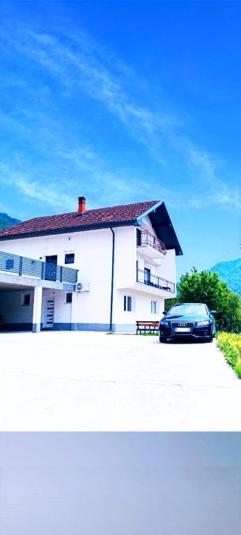 a car parked in front of a white building at Horizontes Azules -Apartments in Konjic
