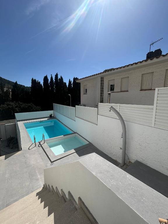 a swimming pool on the side of a house at Casa Roca Maura in L'Estartit