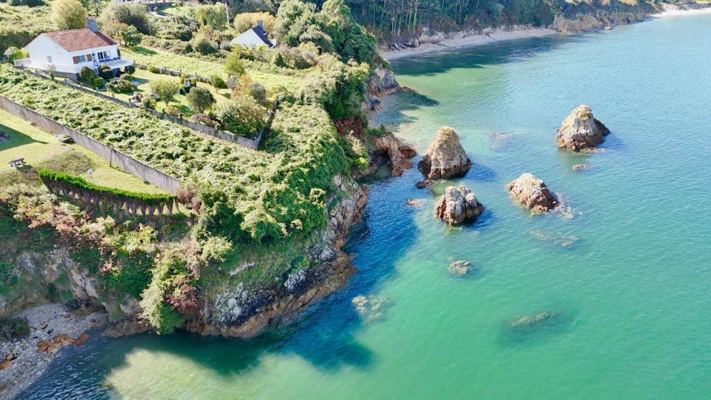 an aerial view of a river with rocks in the water at The Cliffs - ArealongaBeach in O Vicedo