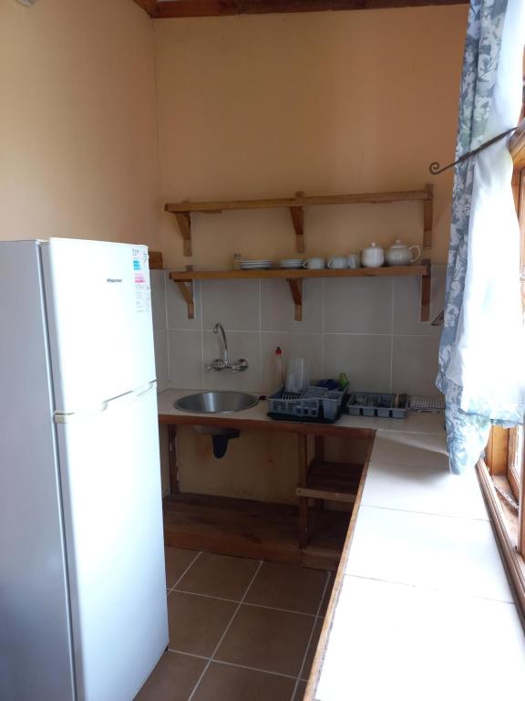 a small kitchen with a sink and a refrigerator at Pecan Cottage Three in Machadodorp