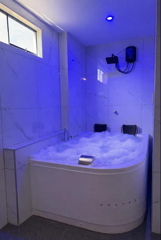 a blue room with a bath tub with a camera at Peruyork - Sauna & Jacuzzi in Chiclayo
