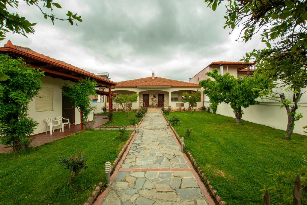 a house with a stone path in front of a yard at Myrtus House in Kato Loutraki