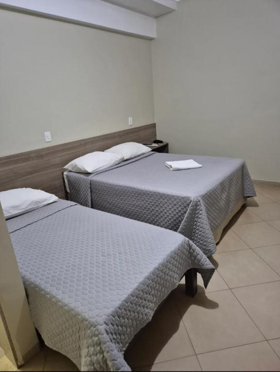 two beds sitting in a room withacers at Hotel Paranoá in Jabuticabal